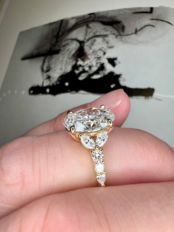 On Hand View From The Side Unique Oval Lab Grown Diamond Engagement Ring With Marquee And Pear Shape Diamonds Accents in Yellow Gold