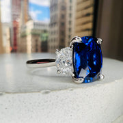 Unique Sapphire Alexandra lab sapphire engagement ring with half-moon, lunette diamonds with NYC as the background. DANA WALDEN BRIDAL.