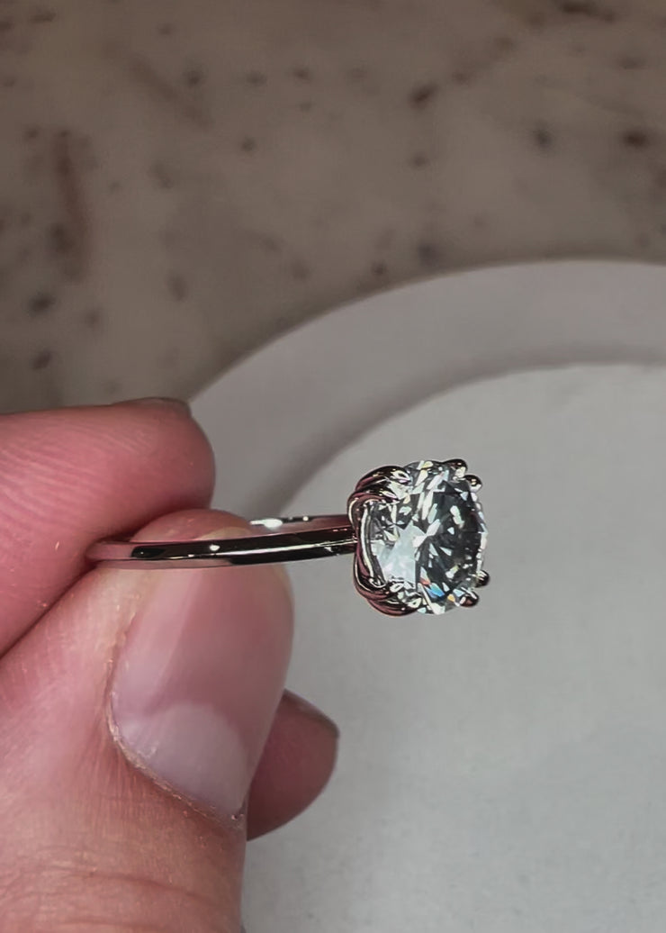 Video of Bailey round brilliant diamond engagement ring with double claw prongs and a thin band.