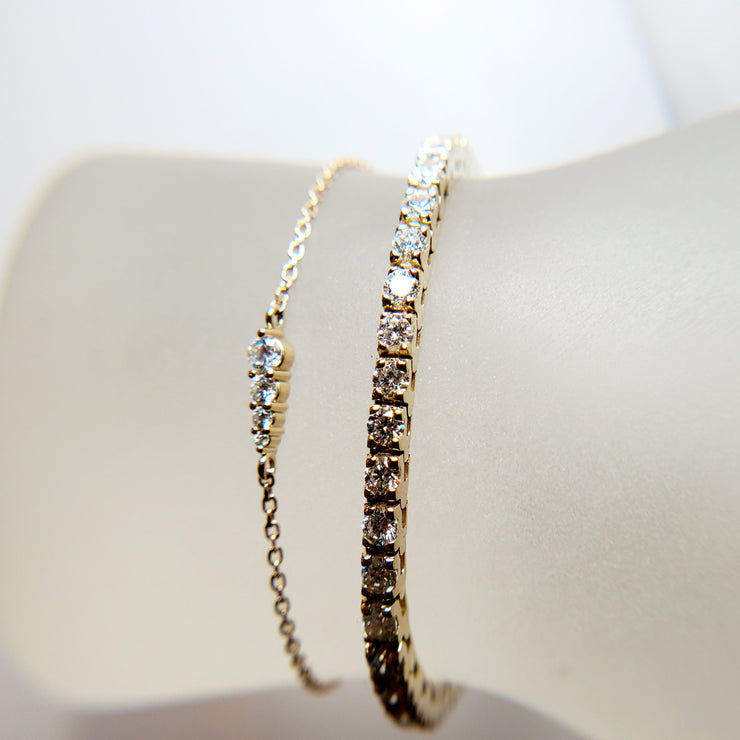 Rise 4 diamond gradating bracelet with petite stones and delicate adjustable chain in 14k yellow gold by Dana Walden Bridal layered with 3.5ctw diamond tennis bracelet in yellow gold