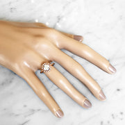 Handmade unique diamond halo engagement ring shown on a model hand. Rose gold setting handmade by Dana Walden Bridal NYC.
