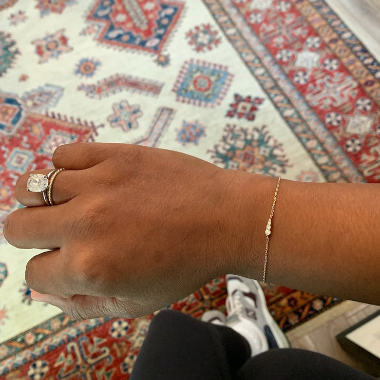 Rad wearing Rise 4 diamond gradating bracelet with petite stones and delicate adjustable chain in 14k yellow gold by Dana Walden Bridal