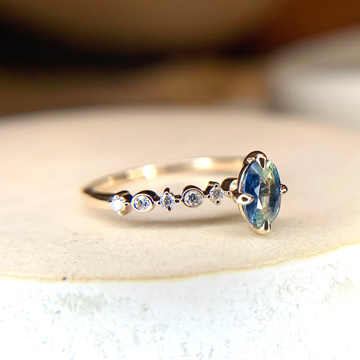 Blue green bicolor sapphire engagement ring with teal hues in yellow gold & diamond band, side profile by Dana Walden Bridal NYC