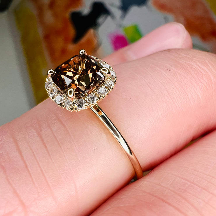 Champagne Diamond Engagement Ring. Natural Cushion cut Champagne diamond with a delicate diamond halo in yellow gold shown on the finger