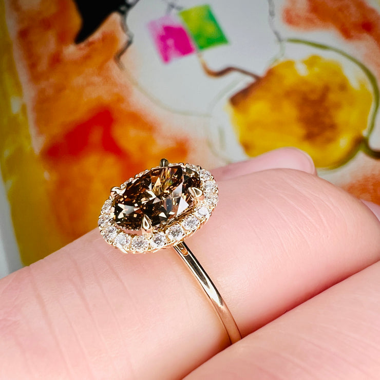 Natural Champagne Diamond Engagement Ring in Yellow Gold with a delicate diamond halo shown on the finger