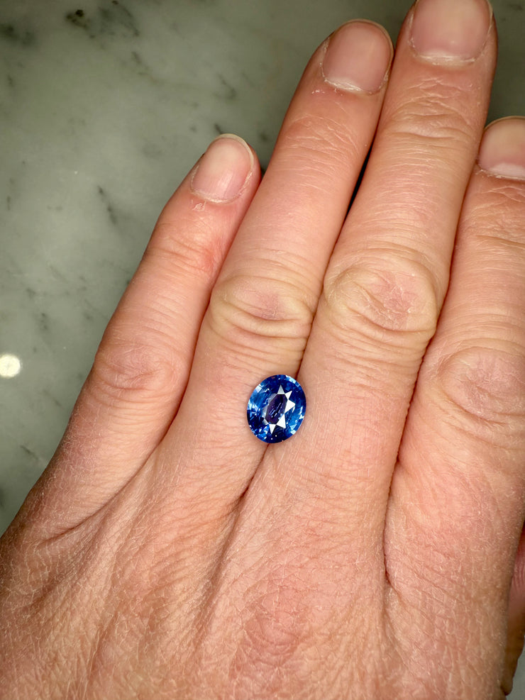 Unique One of A kind natural sapphire for use in a custom engagement ring shown on hand for scale