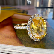 shown on a colorful background Andaz 4.61 Carat Natural Oval-Cut Yellow Sapphire Halo Engagement Ring Eco-Friendly 18k Yellow Gold