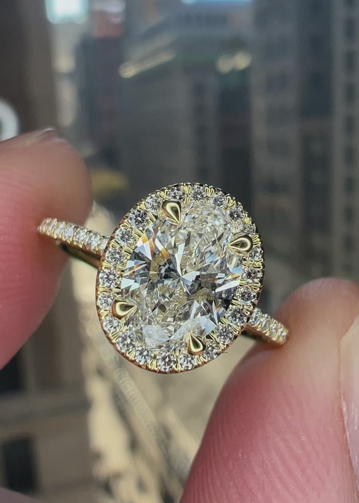 Video of our LINZA ultra thin seamless diamond halo. The center is an oval lab grown diamond and it is made in 18k yellow gold for a wedding ring to sit flush. The micro pave band is very thin as is the diamond halo. Made in NYC.