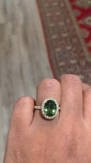 Green sapphire engagement ring with diamond halo. Rad's hand. Dana Walden Bridal.