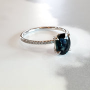 Uma 1.48 carat oval teal sapphire engagement ring in 14k white gold with thin micro-pave diamond band by Dana Walden Bridal in NYC