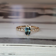 Petite light blue sapphire engagement ring with NSEW prongs in 14k yellow gold with delicate and unique diamond band 