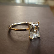 Side profile of Silas engagement ring with 1.57 carat lab grown emerald cut diamond in recycled 14k yellow gold setting with thin dainty band and hidden halo