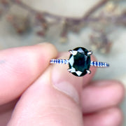 Penelope oval teal sapphire engagement ring with natural blue sapphire accents. Handmade by Dana Walden NYC.