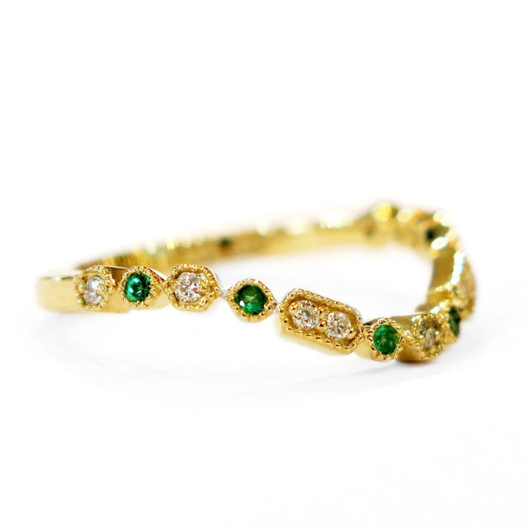 SIDE VIEW- A gently curved emerald and gold wedding ring set in yellow gold. DANA WALDEN BRIDAL NYC.