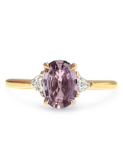 Mauve sapphire engagement ring flanked by trillion shaped diamonds in yellow gold, designed by dana walden bridal