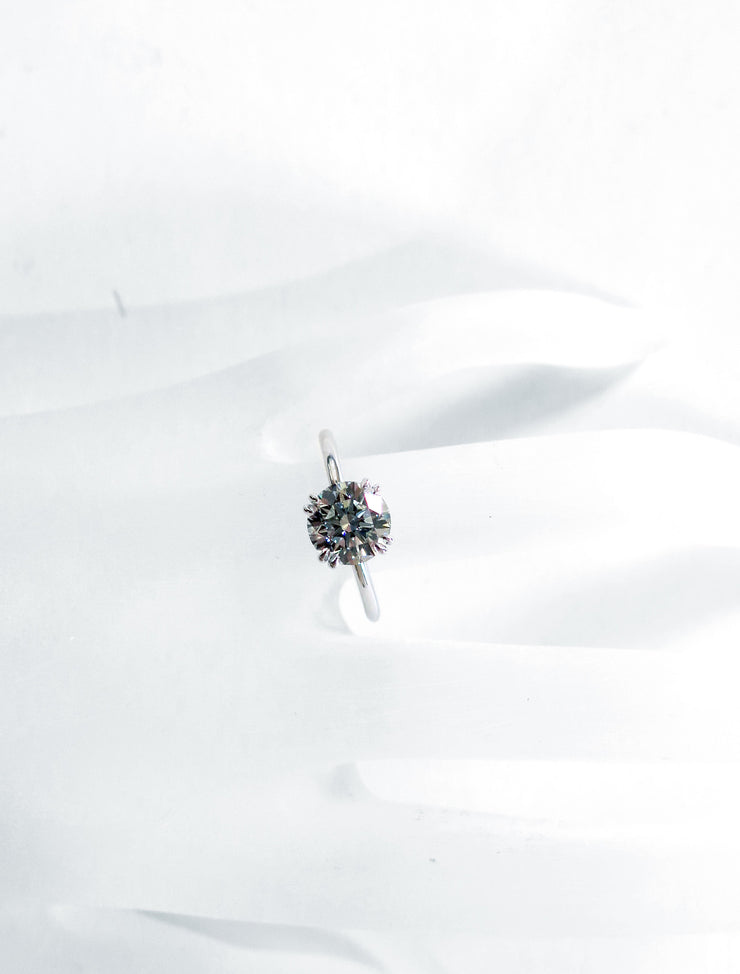 Delicate diamond solitaire on hand with thin band and double claw prongs in platinum - Bailey