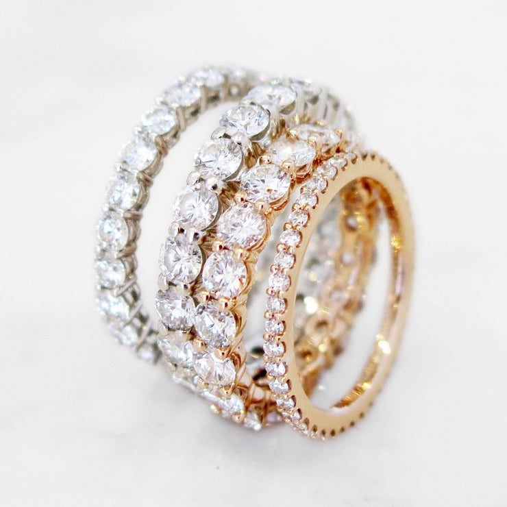 Constance round brilliant diamond eternity bands in varying sizes and metals including rose gold, yellow gold, and white gold. DANA WALDEN BRIDAL.