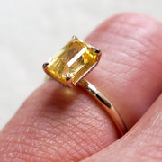 Unique yellow sapphire engagement ring on hand in thin gold custom setting