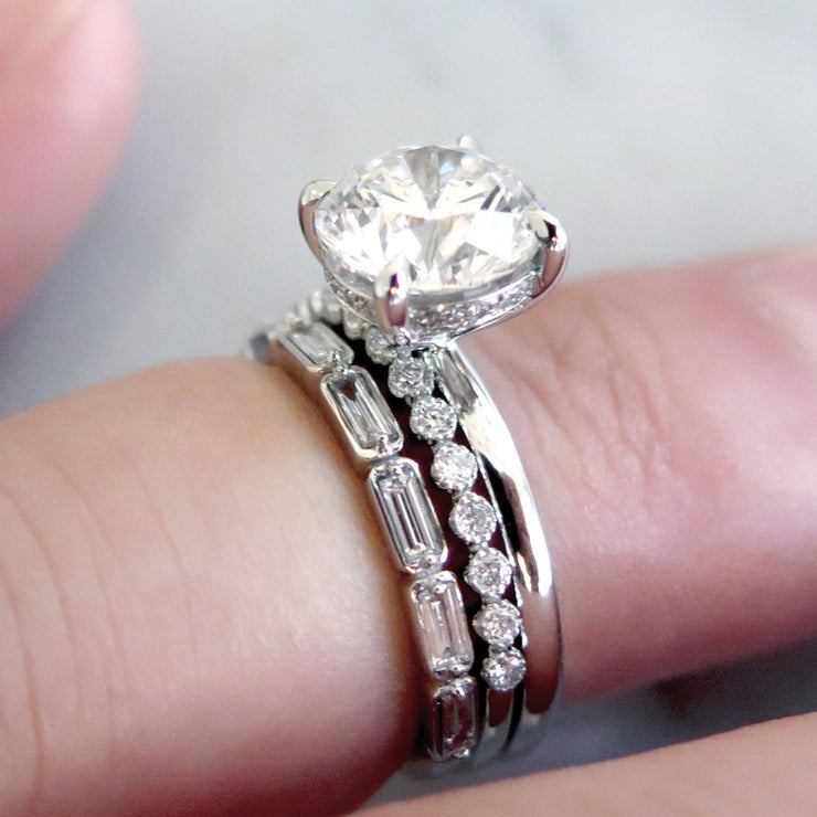 Unique diamond solitaire with thin diamond stacking bands in platinum on hand