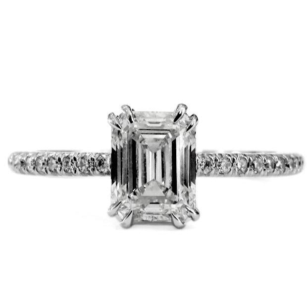 Platinum engagement ring with emerald-cut center diamond and micro pave band. Ethically handmade in NYC.