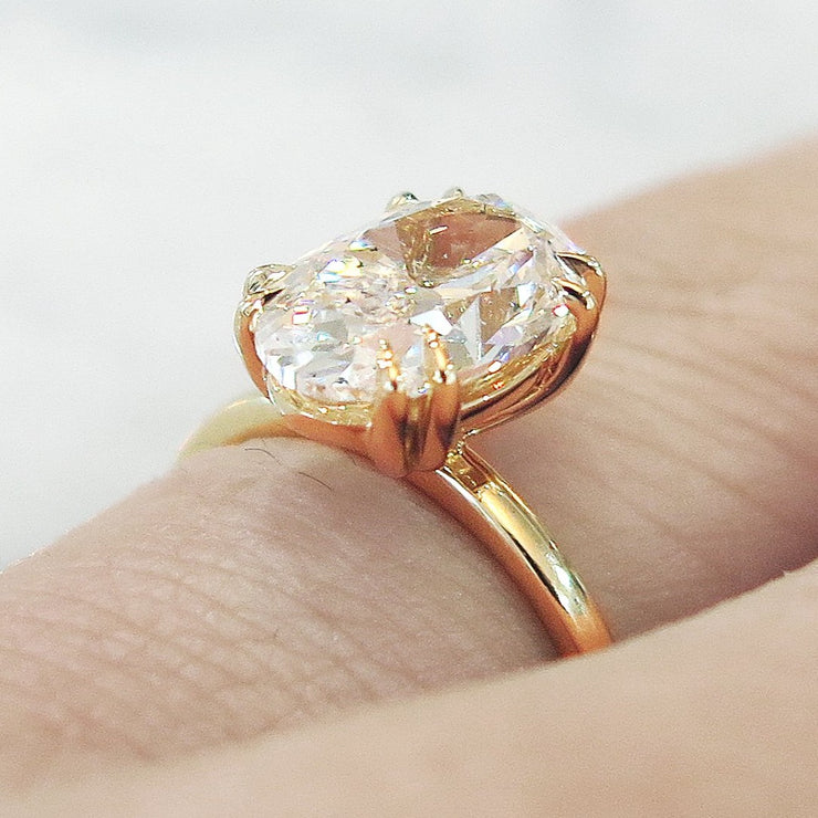 Oval diamond engagement ring, yellow gold solitaire, low profile & delicate, on hand, 2 carat diamond