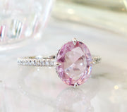 Large 2.25 carat peach sapphire engagement ring with delicate band and diamond accents