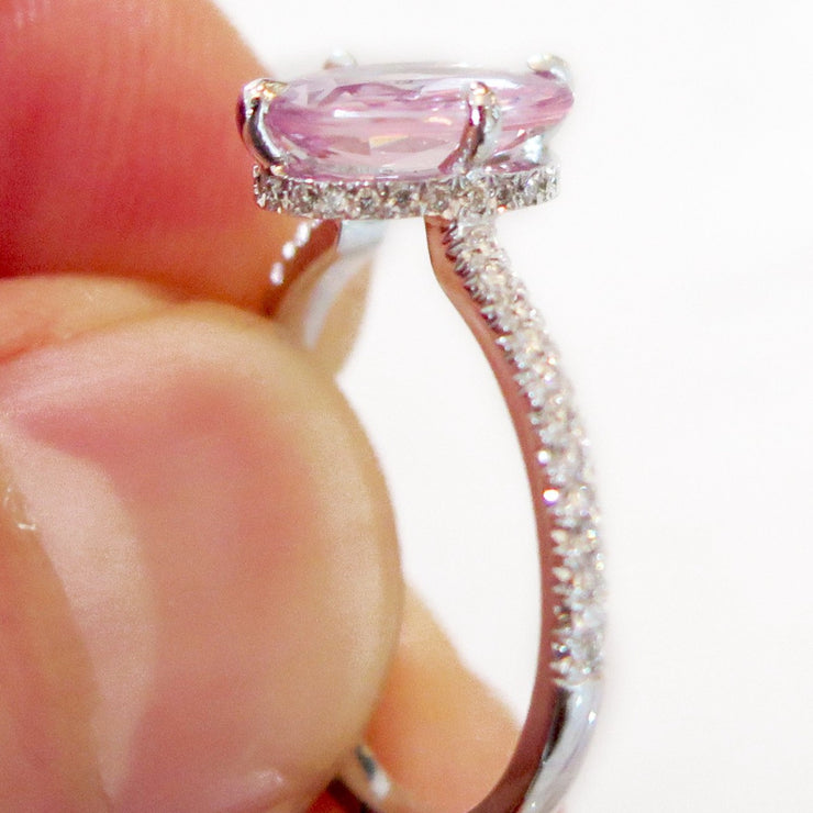 Custom design peach sapphire ring in white gold with conflict-free diamonds up-close in hand