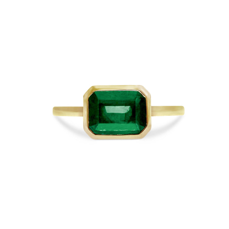 Emerald-cut emerald solitaire engagement ring set in 14k yellow gold. DANAN WALDEN BRIDAL.