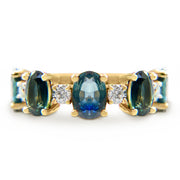 A band-style ring with Oval teal sapphires and round diamond accents. Handmade in NYC.