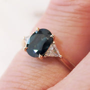 Oval Sapphire Three Stone Engagement Ring with Trillion Diamonds in Rose Gold on Hand