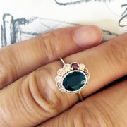 Unique sapphire engagement ring on the designer, Dana Chin's hand. A design sketch is shown in the background. Made in New York City.