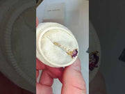 Video Oval purple sapphire engagement ring with delicate diamond band in yellow gold and NSEW compass prongs by Dana Walden Bridal NYC