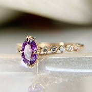 Unique purple oval sapphire engagement ring in yellow gold with diamond accents by Dana Walden Bridal in NYC