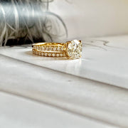 DIamond solitaire engagement ring set in yellow gold, shown with a micro pave matching wedding band. 