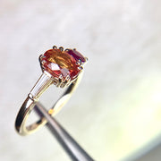 Asymmetrical cluster engagement ring with orange sapphire, ruby, and diamond baguette in yellow gold by Dana Walden Bridal NYC