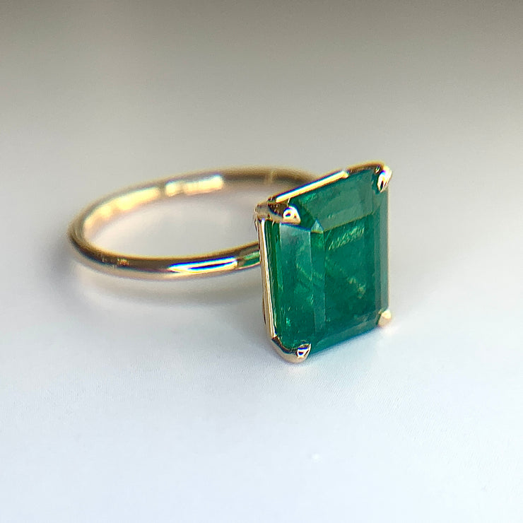 Lenka 4 carat emerald engagement ring with a thin gold band and low profile setting