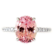 Padparadscha pink lab sapphire engagement ring with white diamond accents. DANA WALDEN BRIDAL NYC.
