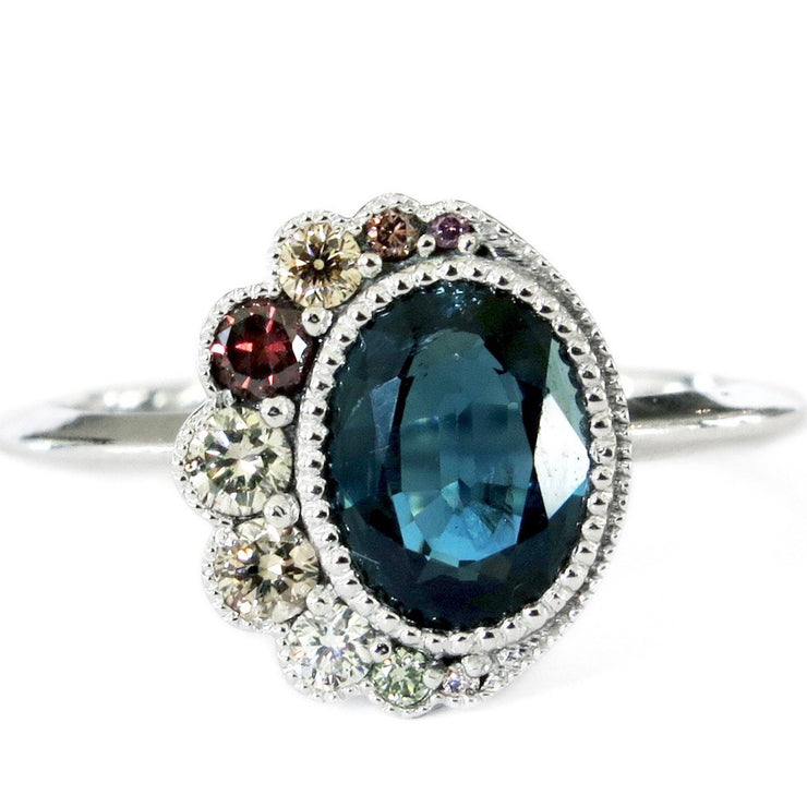 Ethical blue sapphire engagement ring with demi halo of fancy colored diamonds. Unique engagement ring by Dana Walden Bridal Jewelry