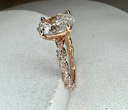 Side view of engagement ring with twisted diamond band and 1.47 carat oval lab grown center diamond in 18k rose gold