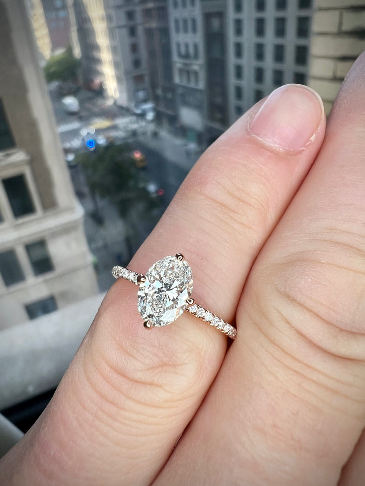 close up on hand of Milly 1.01 carat lab grown diamond engagement ring with thin diamond micro-pavé band and low set diamond in sustainable 14k rose gold with compass NSEW claw prongs 