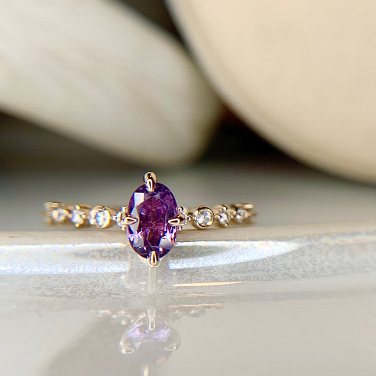 Purple sapphire engagement ring with NSEW prongs in yellow gold with diamond accents and thin band by Dana Walden Bridal NYC