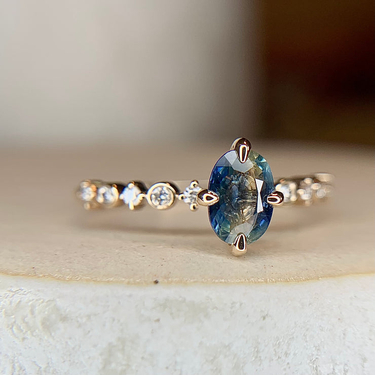 Blue green bicolor sapphire engagement ring with teal hues in yellow gold & diamond band by Dana Walden Bridal NYC