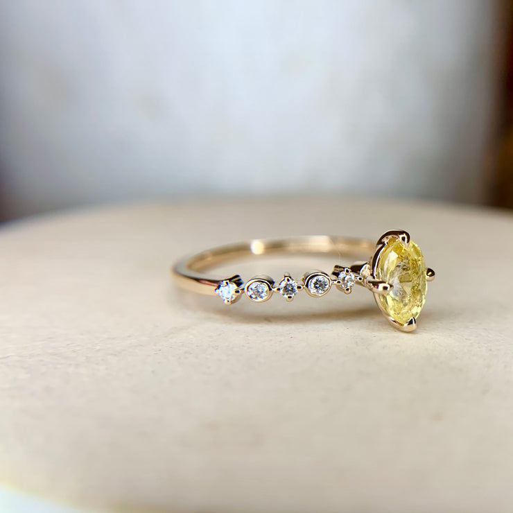 Oval yellow sapphire engagement ring with intricate diamond band in yellow gold by Dana Walden Bridal, NYC