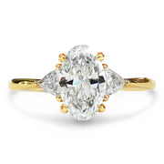 Lucine oval cut diamond 3 stone engagement ring in yellow gold with trillion side stones on hand