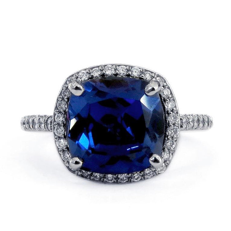Cushion cut deep blue sapphire engagement ring with diamond halo. By Dana Walden Bridal NYC.