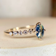Blue green bicolor sapphire engagement ring with teal hues in yellow gold & diamond band by Dana Walden Bridal NYC