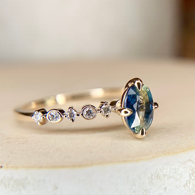 Blue green bicolor sapphire engagement ring with teal hues in yellow gold & diamond band by Dana Walden Bridal NYC