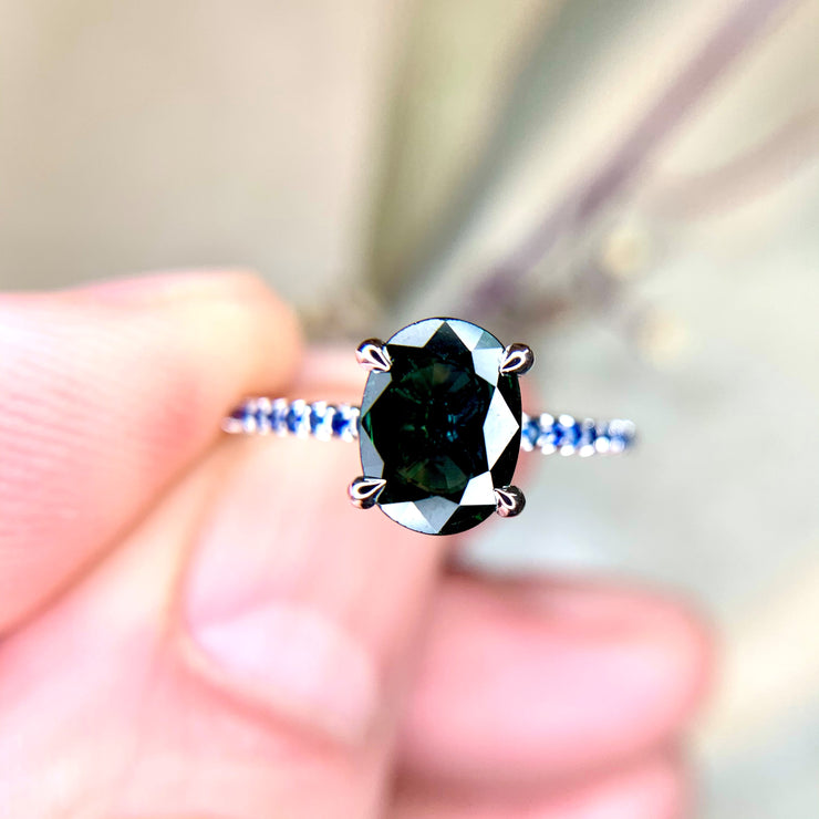 Penelope oval teal sapphire engagement ring with natural blue sapphire accents. Handmade by Dana Walden NYC.